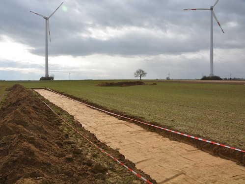 Baustelle mit Windrädern im Hintergrund