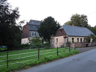 Gebäude (ehemalige Eisenhütte Abentheuer) an einer Straße und Wiese gelegen