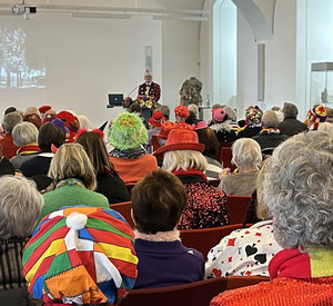 Maskierte Menschen hören einem Vortrag zu