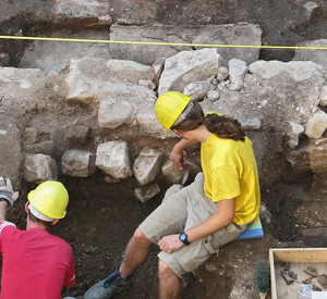 3 Personen führen im sitzten eine archäologische Grabung durch