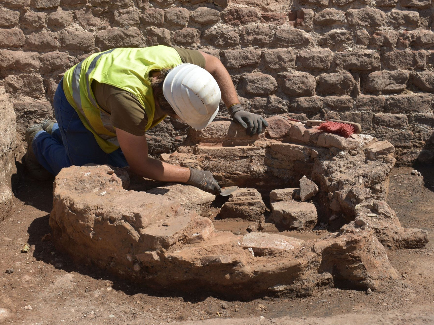 Ein Mann gräbt die Überreste eines alten Brunnen aus