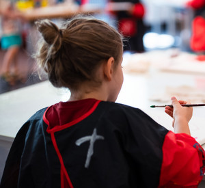 Kinder sitzen an einem Tisch und malen