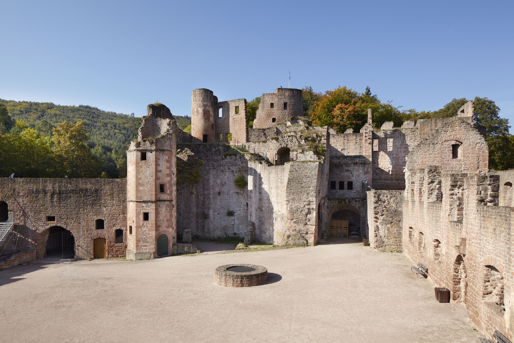 Mauer- und Turmruinen einer Burg mit großen Platz in der Mitte
